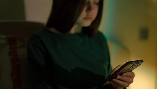 A young person looking at their phone